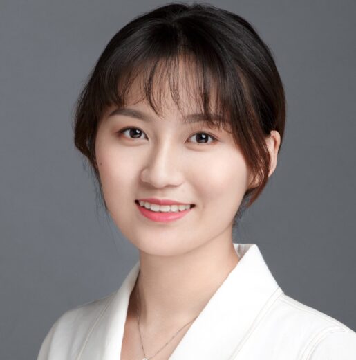 Jing Ma smiling and wearing business attire.